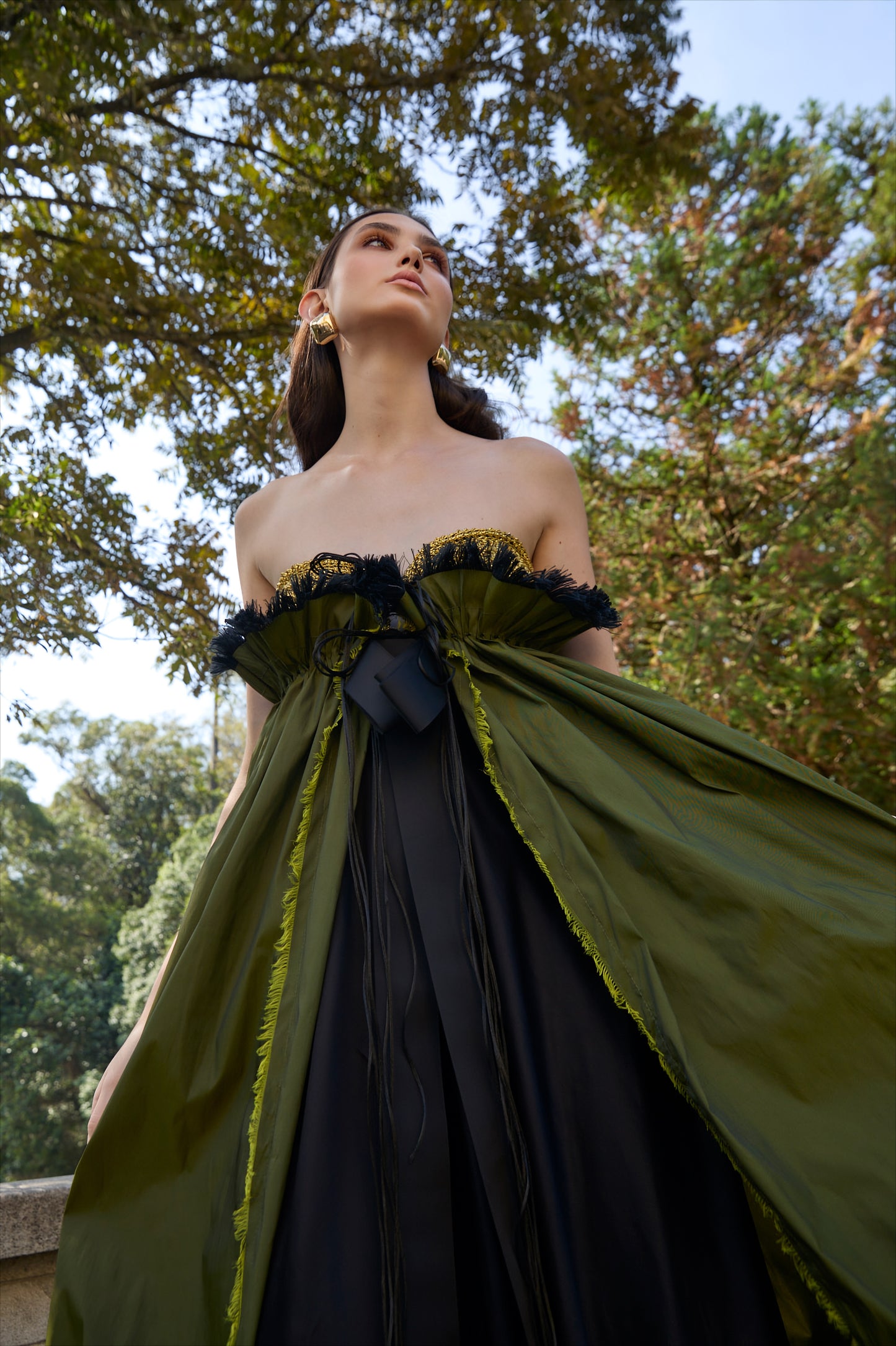 Vestido de festa longo da marca Isabela Monteiro. Bustier dourado feito à mão em croche, saia de tafetá verde chageant com detalhe franzido e desfiado à mão, com saia de cetim de seda pura preta. Decote nas costas. 