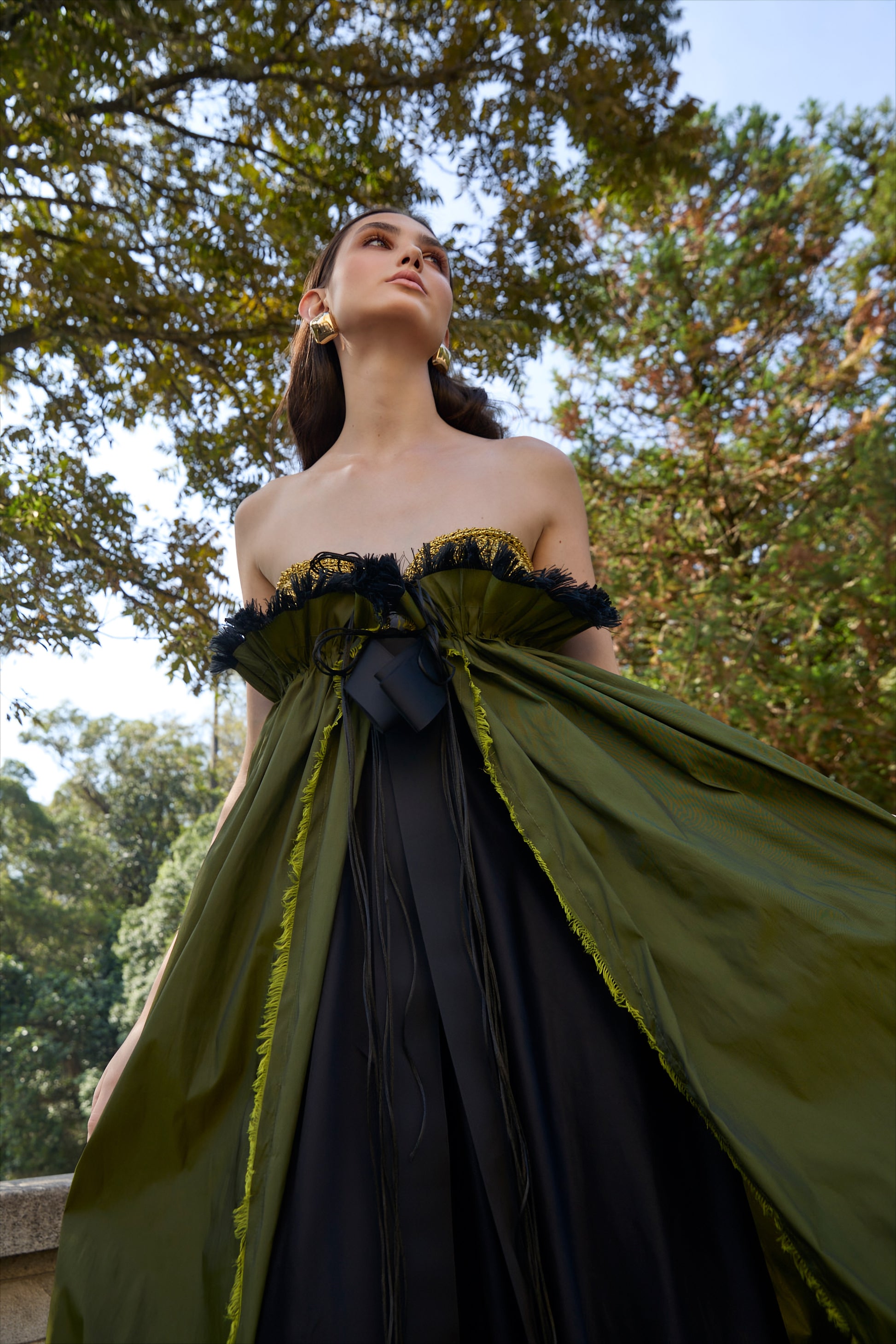 Vestido de festa longo da marca Isabela Monteiro. Bustier dourado feito à mão em croche, saia de tafetá verde chageant com detalhe franzido e desfiado à mão, com saia de cetim de seda pura preta. Decote nas costas. 