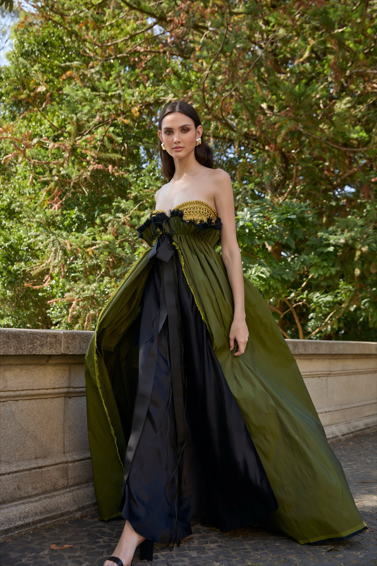 Vestido de festa longo da marca Isabela Monteiro. Bustier dourado feito à mão em croche, saia de tafetá verde chageant com detalhe franzido e desfiado à mão, com saia de cetim de seda pura preta. Decote nas costas.
